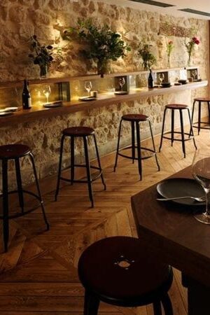 Nicolle metal bar stool H75-cm. Metal stool with patinated steel finish and leather cushion at Freddy's Restaurant in Paris.