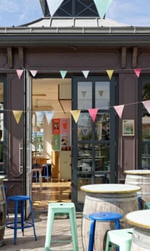 Terrasse d'un café avec guirlandes colorées.