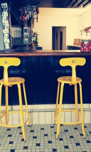 Une maison dans un ancien café avec des chaise de bar vintage en réédition