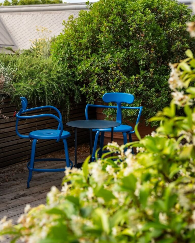 Fauteuil de jardin Nicolle fabriqué en France dans un jardin verdoyant.