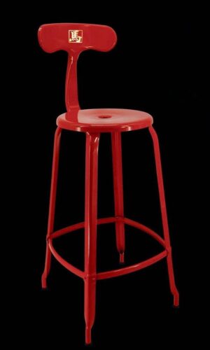 Red metal stool on a black background.